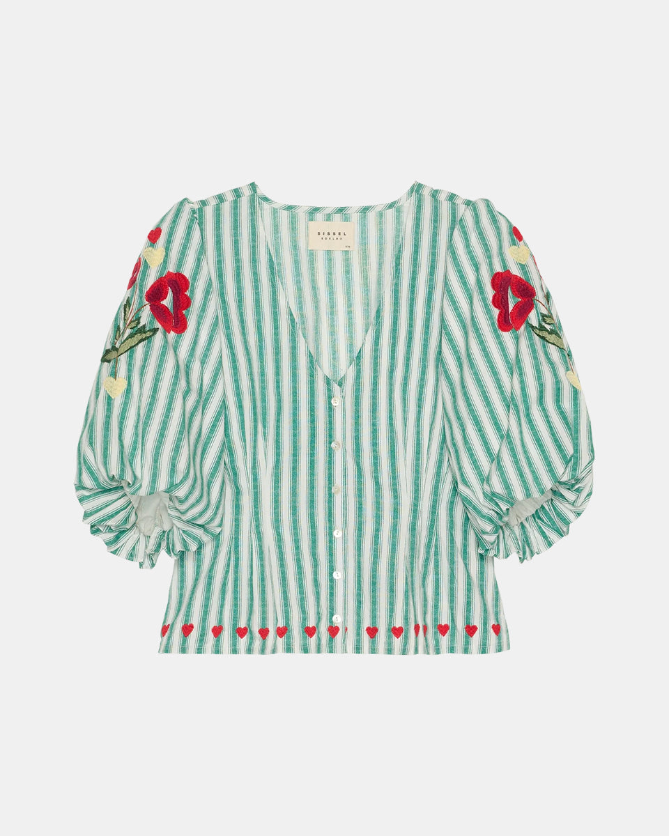 Kobieca bluzka koszulowa Lotta Green Stripes SISSEL EDELBO z dopasowaną talią i marszczeniem z tyłu. Ma głęboki dekolt w serek i zapięcie z przodu na guziki z masy perłowej. Rękawy mają długość 3/4 i zakończone są gumką. Ozdobiona jest delikatnym haftem kwiatowym i serduszkami. Wykonana z organicznej bawełny popelinowej w paski.&nbsp;

-Dopasowana talia

-100% bawełna organiczna

-Zamów bluzkę w swoim standardowym rozmiarze&nbsp;