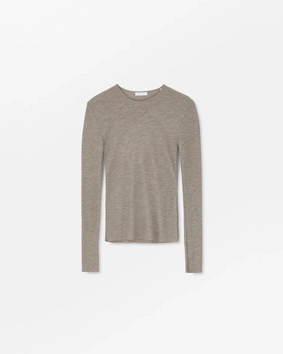 Minimalistyczny, cienki, wełniany longsleeve Amy O-neck SKALL z okrągłym dekoltem i wąskimi, długimi rękawami. Posiada przylegający do ciała fason i delikatną fakturę w prążki