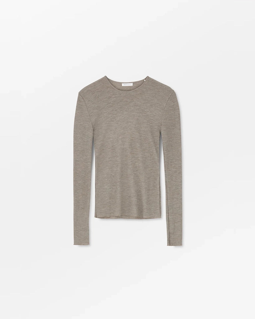 Minimalistyczny, cienki, wełniany longsleeve Amy O-neck SKALL z okrągłym dekoltem i wąskimi, długimi rękawami. Posiada przylegający do ciała fason i delikatną fakturę w prążki