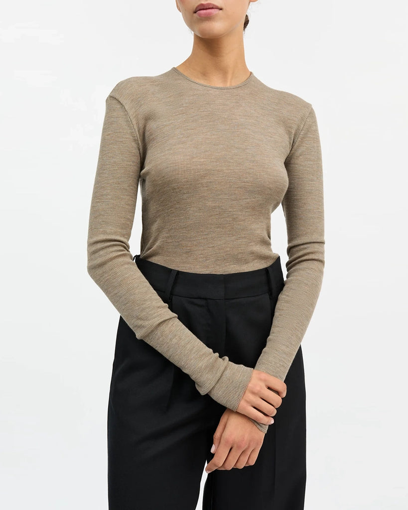 Minimalistyczny, cienki, wełniany longsleeve Amy O-neck SKALL z okrągłym dekoltem i wąskimi, długimi rękawami. Posiada przylegający do ciała fason i delikatną fakturę w prążki