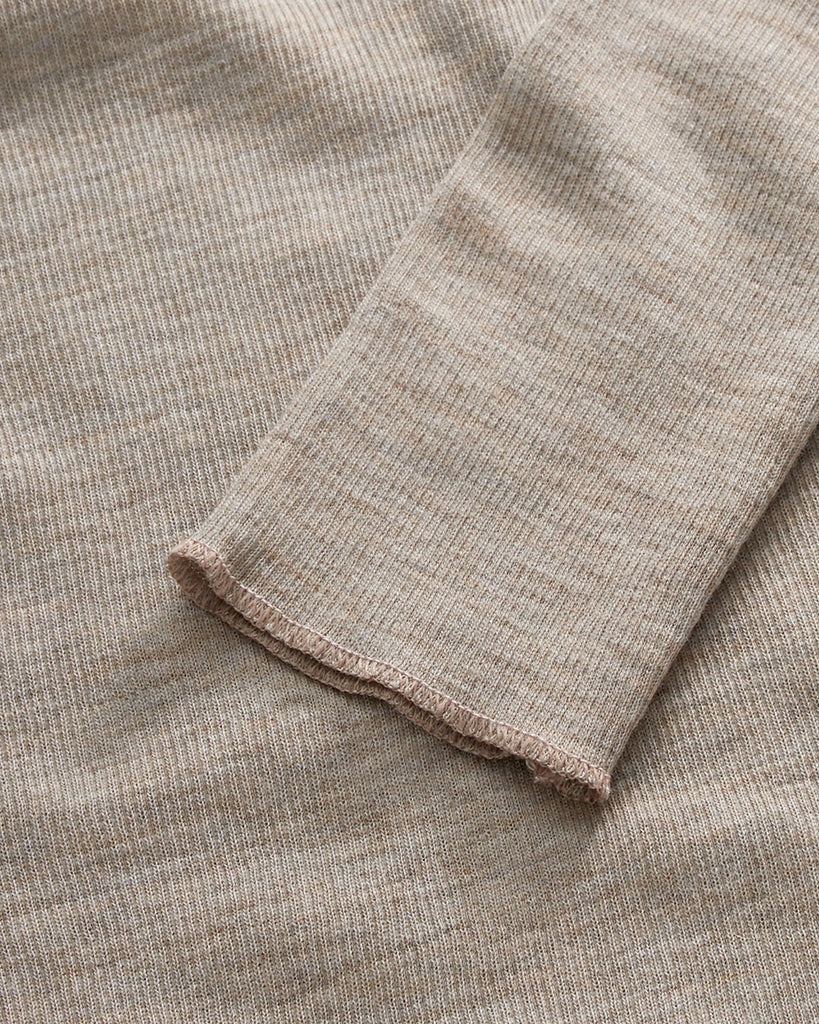 Minimalistyczny, cienki, wełniany longsleeve Amy O-neck SKALL z okrągłym dekoltem i wąskimi, długimi rękawami. Posiada przylegający do ciała fason i delikatną fakturę w prążki