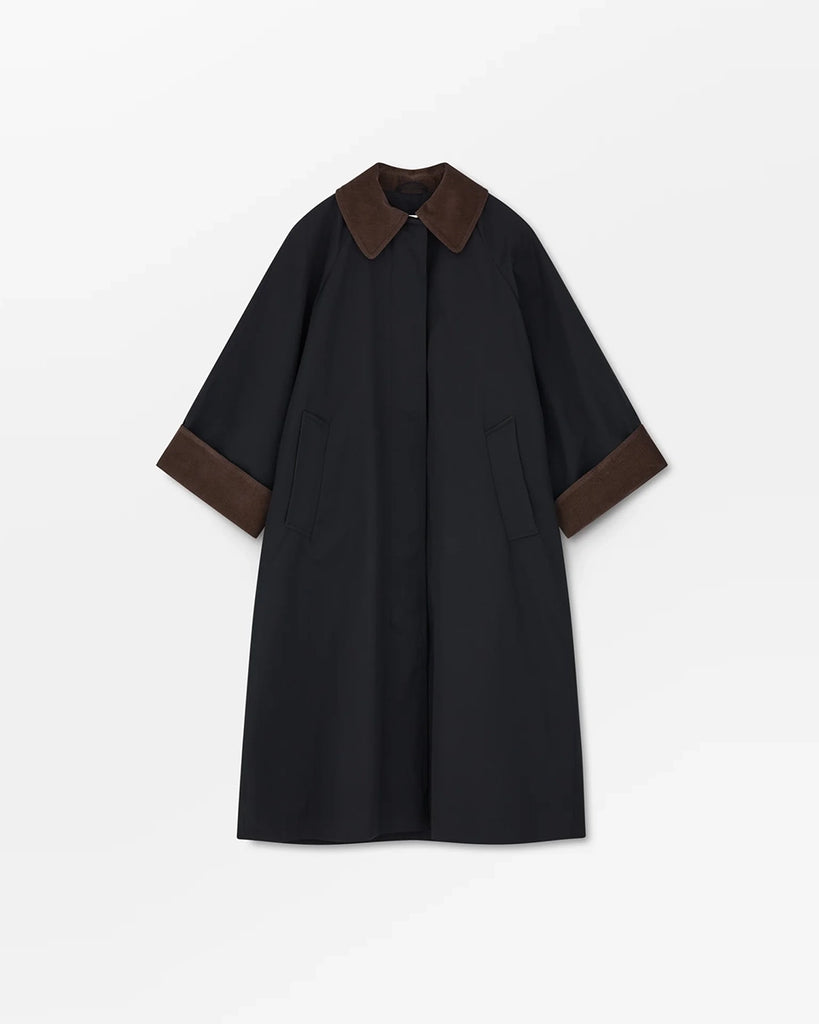 Oversizowy, przejściowy, inspirowany stylem brytyjskim płaszcz Gaby SKALL z dużym kołnierzykiem obszytym brązowym sztruksem i z szerokimi, wywijanymi rękawami ze sztruksowym obszyciem od wewnątrz mankietów. Płaszcz posiada dwie, boczne kieszenie i rozcięcie u dołu z tyłu.