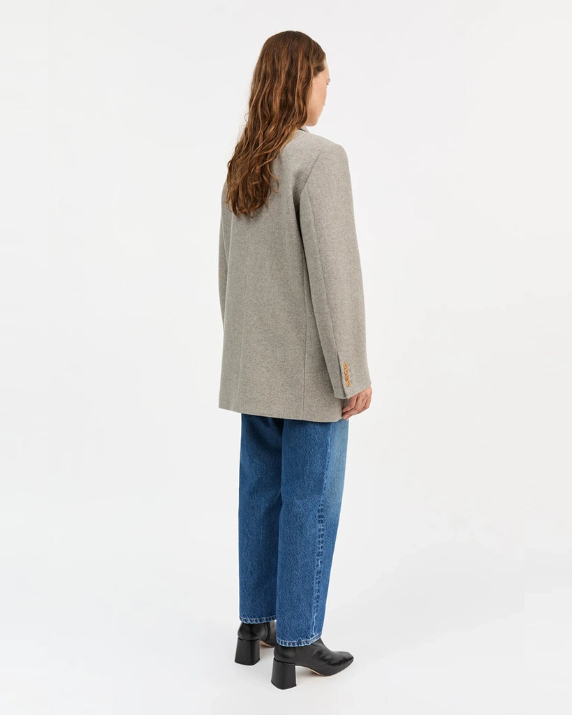 Gruba, długa marynarka z wełny w drobne, skośne prążki Mick SKALL zapinana na dwa rzędy guzików. Posiada prosty krój i długość za biodra. Marynarka ma duży kołnierz, niewielką kieszonkę nad lewą piersią i dwie, przednie kieszenie z klapkami. Przy mankietach zapinana na rząd drobnych guzików.