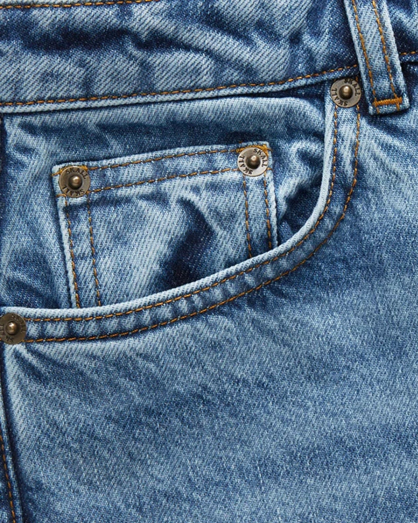 Luźne, niebieskie jeansy Allison SKALL ze średnim stanem i prostą, luźną, lekko skróconą nogawką. Spodnie mają pięć kieszeni i szlufki na pasek. 