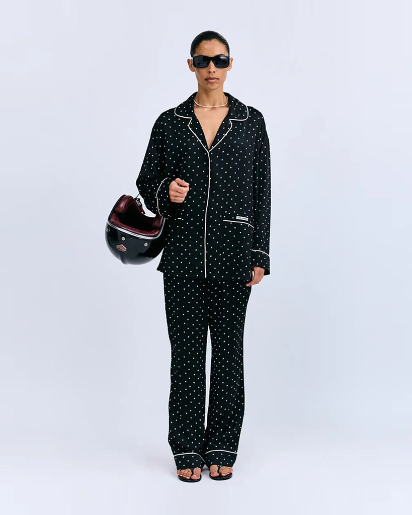 Oversizowa, piżamowa koszula Cedric Love Stories z lejącej, satynowej tkaniny w drobny, kwiatkowy print. Posiada dekolt w kształcie litery V, kołnierzyk i szerokie, długie rękawy. Zapinana na guziki. Obszyta cienką, błękitną lamówką. Koszula ma dwie, przednie kieszenie. Na prawej kieszeni znajduje się niewielka naszywka z logo marki