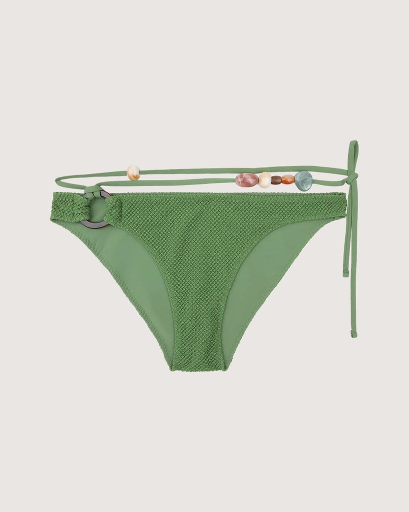 Dół od bikini Coral z dekoracyjnym, szylkretowym kółkiem na biodrze i odwiązywanym sznurkiem z kolorowymi koralikami o nieregularnej wielkości. 