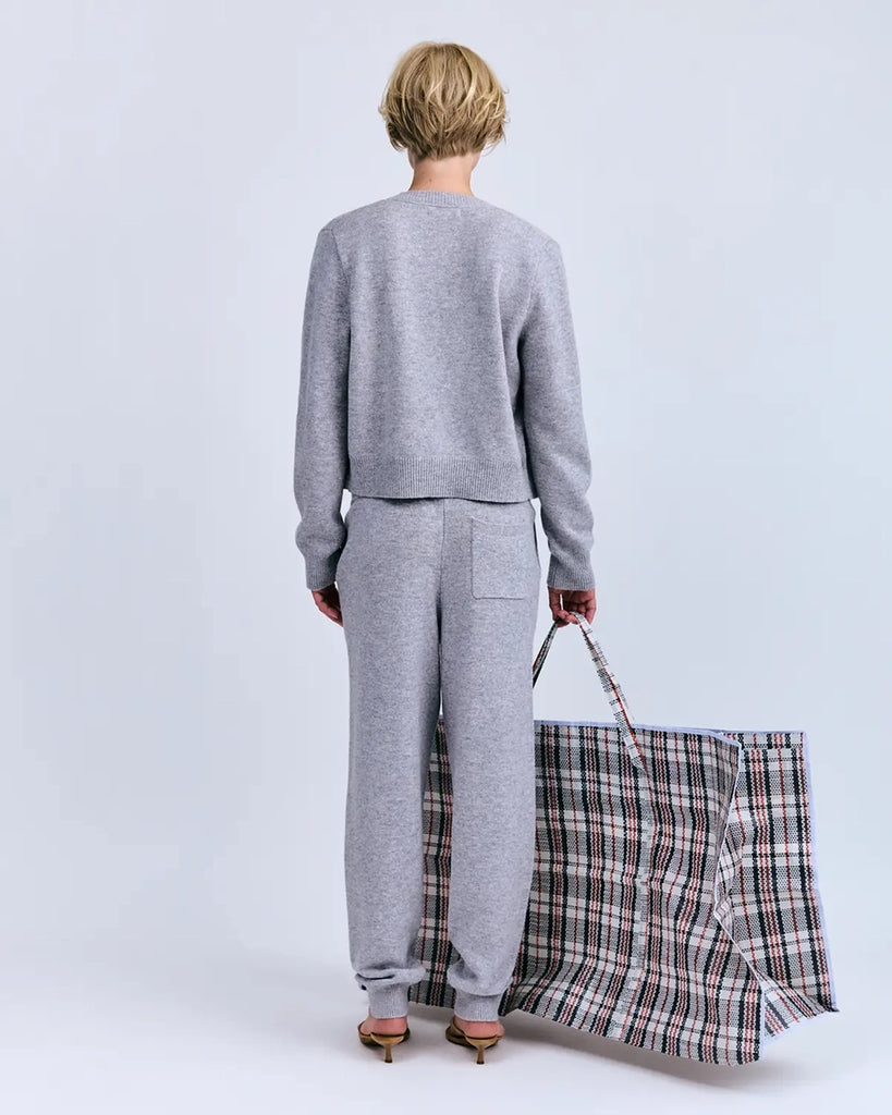 Luźne, szare, dzianinowe spodnie dresowe Donna Love Stories z niskim stanem i zwężaną u dołu nogawką zakończoną ściągaczami. Posiadają dwie, boczne kieszenie i jedną tylną. Elastyczne i wiązane w pasie