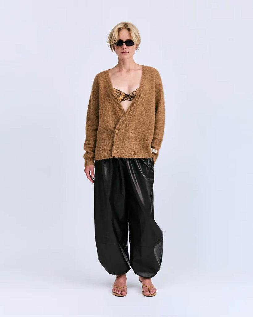 Oversizowy, dwurzędowy sweter Iris Love Stories z głębokim dekoltem w serek. Posiada prosty krój i długość za biodra. Wykonany z bardzo miękkiej i puchatej dzianiny z alpaką. Na lewym rękawie znajduje się niewielka naszywka z logo mark