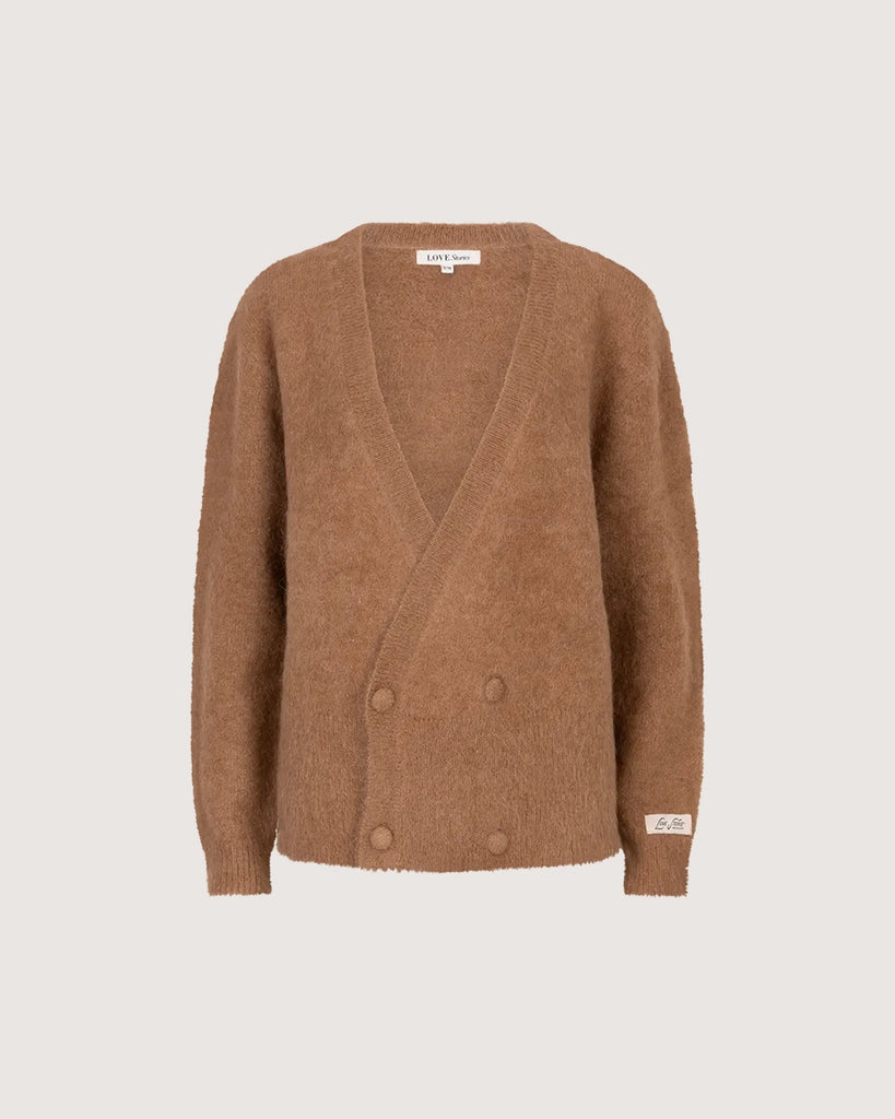 Oversizowy, dwurzędowy sweter Iris Love Stories z głębokim dekoltem w serek. Posiada prosty krój i długość za biodra. Wykonany z bardzo miękkiej i puchatej dzianiny z alpaką. Na lewym rękawie znajduje się niewielka naszywka z logo mark