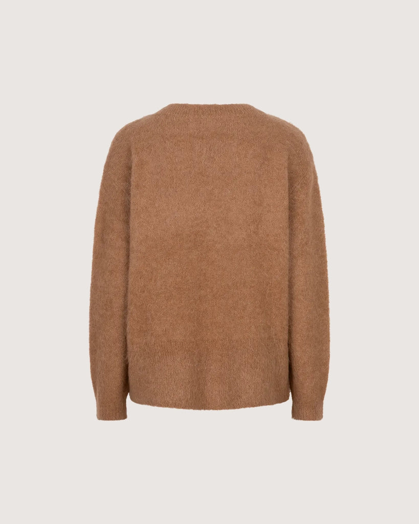 Oversizowy, dwurzędowy sweter Iris Love Stories z głębokim dekoltem w serek. Posiada prosty krój i długość za biodra. Wykonany z bardzo miękkiej i puchatej dzianiny z alpaką. Na lewym rękawie znajduje się niewielka naszywka z logo mark