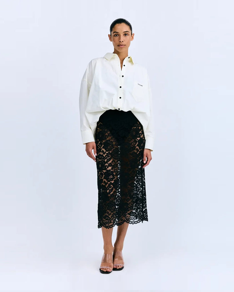 Sukienka midi Joey Love Stories z koszulową, luźną górą i transparentym, koronkowym dołem. Posiada kołnierzyk, opadające ramiona, kieszonkę z naszywką z logo marki i długie rękawy z mankietami. Zapinana na guziki. Sukienka ma długość do połowy łydki. Ma wszyte zakrywające majtki. 