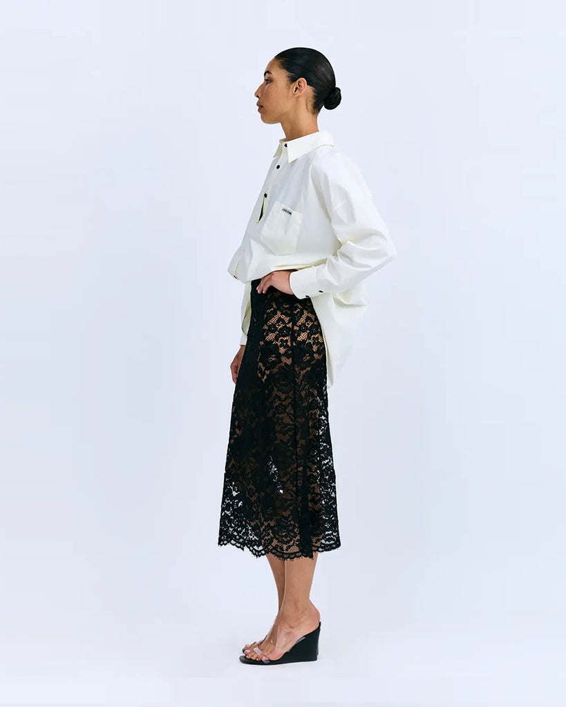 Sukienka midi Joey Love Stories z koszulową, luźną górą i transparentym, koronkowym dołem. Posiada kołnierzyk, opadające ramiona, kieszonkę z naszywką z logo marki i długie rękawy z mankietami. Zapinana na guziki. Sukienka ma długość do połowy łydki. Ma wszyte zakrywające majtki. 