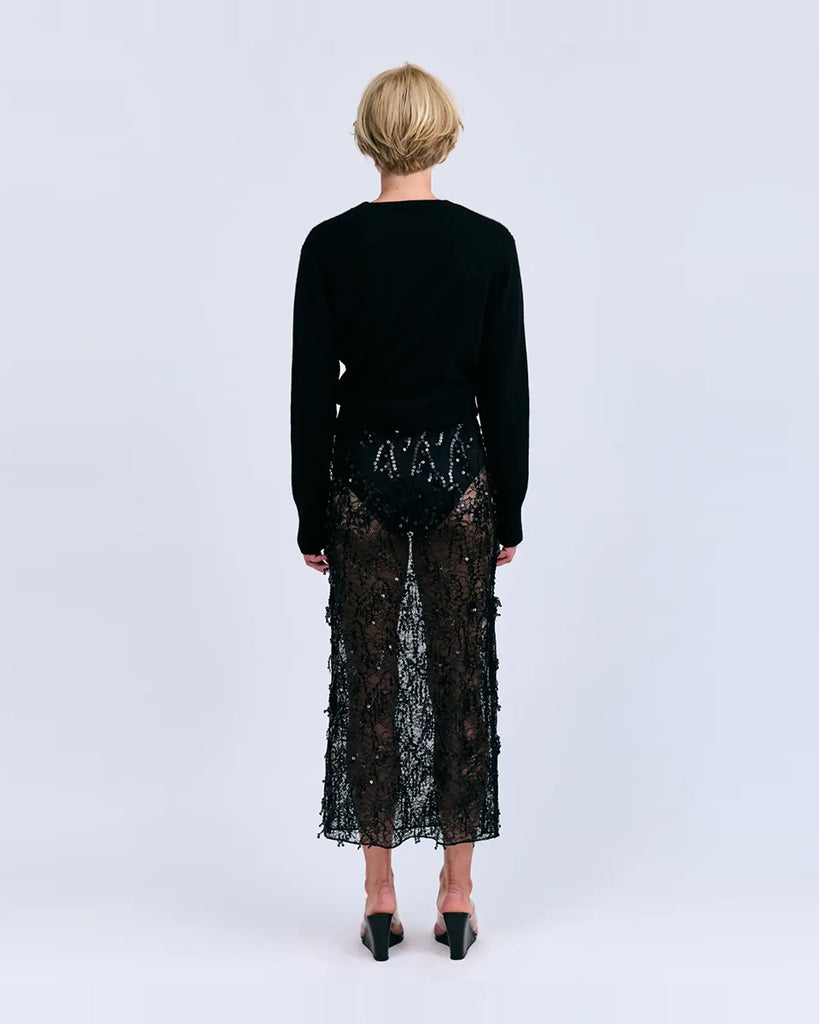 Czarna, transparentna, koronkowa spódnica midi Mia Love Stories z wysokim stanem i elastyczną talią. Posiada długość przed kostki. Idealna do luźnego swetra lub oversizowej koszuli.