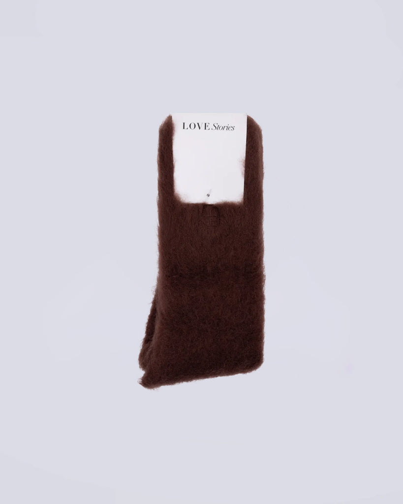 Długie, brązowe, puszyste skarpetki Love Stories z niewielkim logo marki. Wykonane są z mieszanki wełny, dzięki czemu są mięciutkie i wygodne.