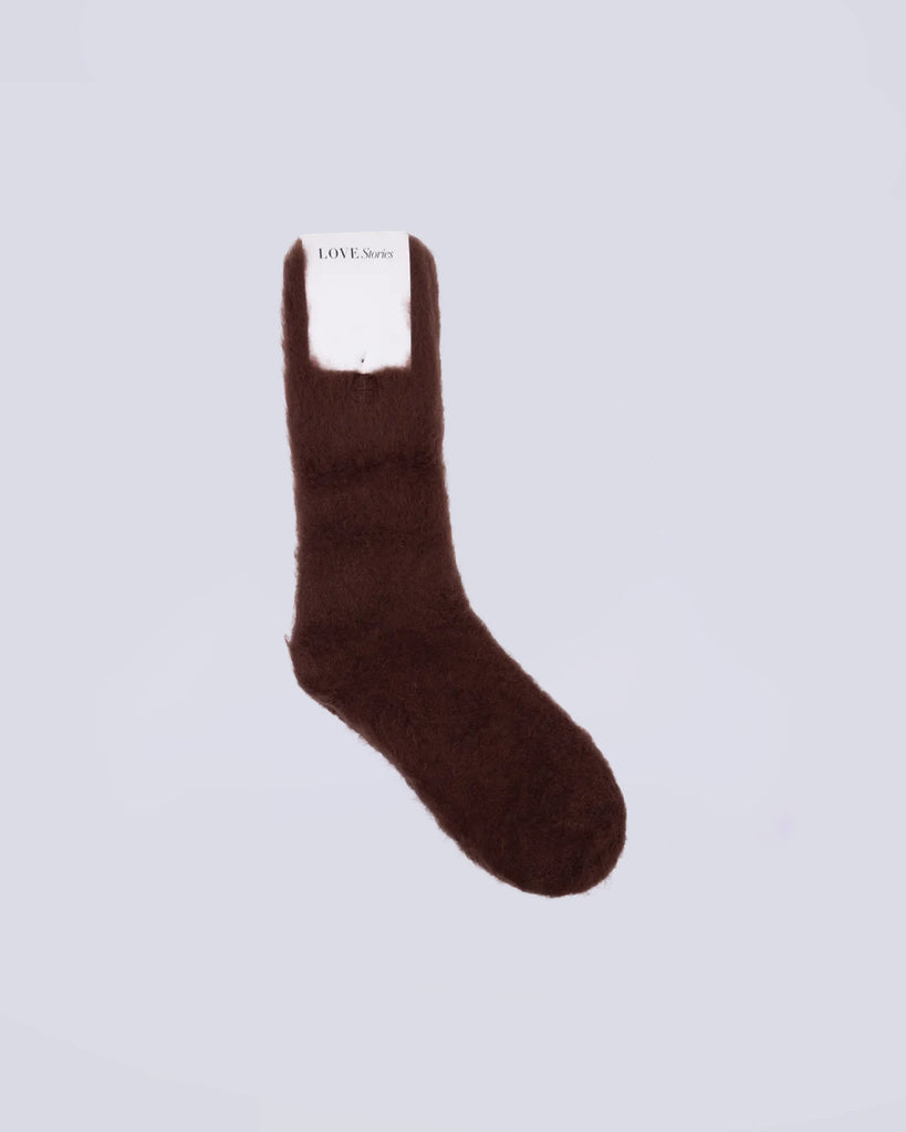 Długie, brązowe, puszyste skarpetki Love Stories z niewielkim logo marki. Wykonane są z mieszanki wełny, dzięki czemu są mięciutkie i wygodne.