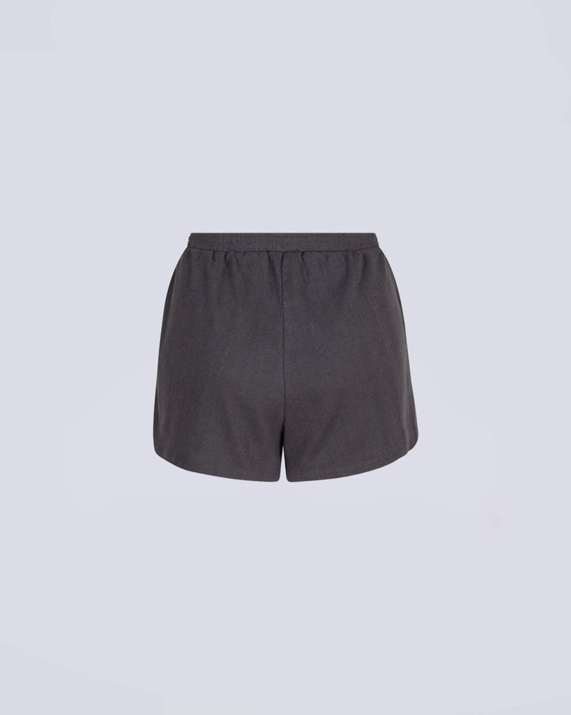 Luźne, ciemnoszare szorty w typie bokserek Sunday Love Stories ze średnim stanem i elastyczną talią. Z przodu posiadają niewielką naszywkę z logo marki i imitację rozporka z guzikami. Wykonane z bardzo miękkiej i oddychającej tkaniny.&nbsp;