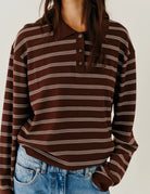 Luźny, dzianinowy longsleeve Madison Polo Espresso/Ecru w głębokim, ciepłym, brązowym odcieniu w paski, z obniżoną linią ramion i klasycznym kołnierzykiem z zapięciem na trzy guziki. Rękawy i dół zakończone są klasycznymi ściągaczami. Ma gładki, drobny splot dzianinowy. Wykonany z tkaniny z wiskozą. Zestaw go z ulubionymi jeansami, aby uzyskać klasyczną, modną stylizację.&nbsp;

-Głęboki, ciepły odcień brązu, paski

-Kołnierzyk z guziczkami

-Tkanina z wiskozą

-Fason OVERSIZE - jeśli chcesz uzyskać efekt j