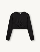 Czarny, dopasowany top Madison Black marki The Garment o minimalistycznym, wyrazistym kroju. Ma okrągły, zabudowany dekolt i długie rękawy. U dołu materiał jest zebrany i związany w supeł, co tworzy delikatne marszczenie i skróconą długość odsłaniającą brzuch. Wykonany z miękkiej, przylegającej do ciała tkaniny.

-Dopasowany krój

-Skrócona długość&nbsp;

-Zamów top w swoim standardowym rozmiarze
