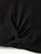 Czarny, dopasowany top Madison Black marki The Garment o minimalistycznym, wyrazistym kroju. Ma okrągły, zabudowany dekolt i długie rękawy. U dołu materiał jest zebrany i związany w supeł, co tworzy delikatne marszczenie i skróconą długość odsłaniającą brzuch. Wykonany z miękkiej, przylegającej do ciała tkaniny.

-Dopasowany krój

-Skrócona długość&nbsp;

-Zamów top w swoim standardowym rozmiarze