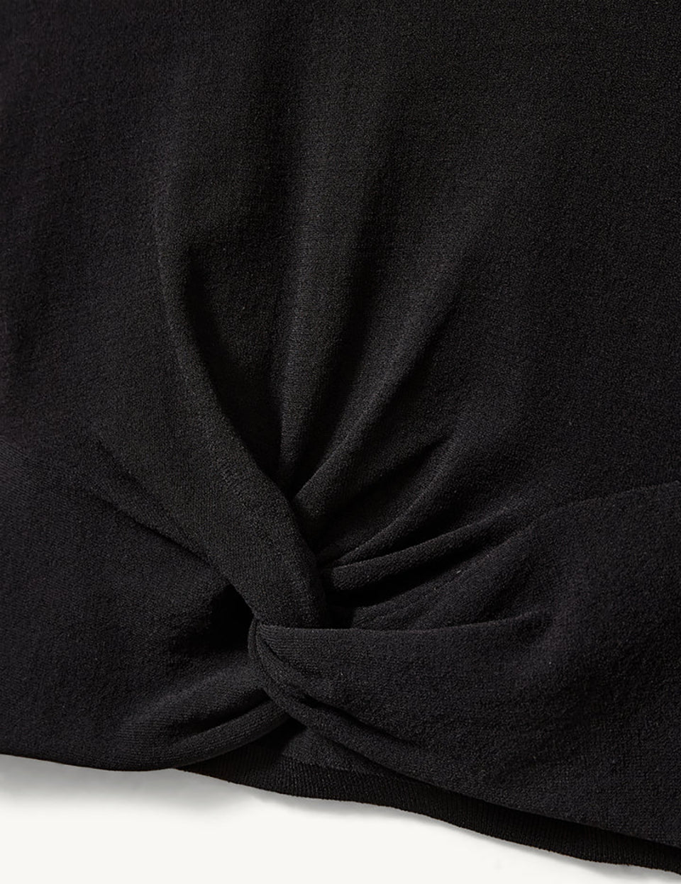 Czarny, dopasowany top Madison Black marki The Garment o minimalistycznym, wyrazistym kroju. Ma okrągły, zabudowany dekolt i długie rękawy. U dołu materiał jest zebrany i związany w supeł, co tworzy delikatne marszczenie i skróconą długość odsłaniającą brzuch. Wykonany z miękkiej, przylegającej do ciała tkaniny.

-Dopasowany krój

-Skrócona długość&nbsp;

-Zamów top w swoim standardowym rozmiarze