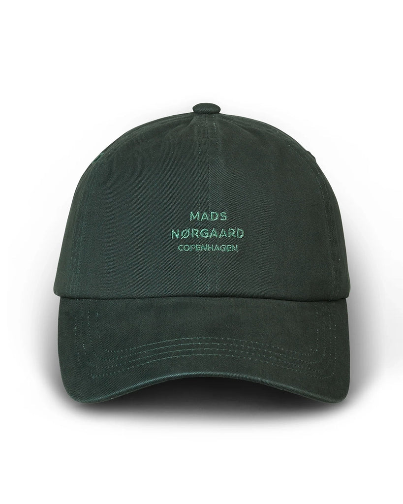 Klasyczna czapka z daszkiem Cash MADS NORGAARD. Z przodu posiada niewielki haft z logo marki. Regulowana za pomocą paska z tyłu.