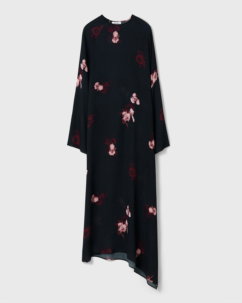 Długa, luźna sukienka Marge Wine Black w kolorze czarnym z kwiatowym printem. Ma okrągły dekolt z wiązaniem z tyłu oraz raglanowe, przedłużone rękawy. Dół sukienki jest asymetryczny.&nbsp;