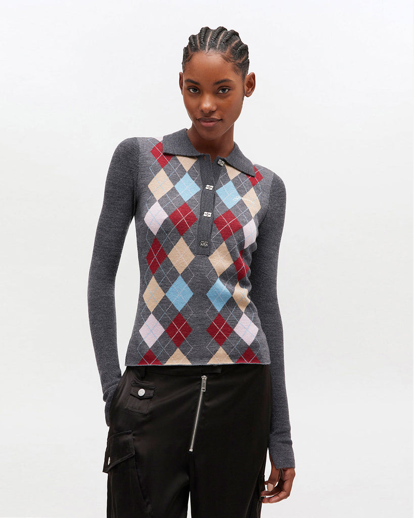 Cienki sweter polo 2601 GANNI z kołnierzykiem. Ma wzór w romby. Zapinany przy dekolcie za pomocą srebrnych, ozdobnych guzików w kształcie logo marki. Sweter ma prosty krój i przylegający do ciała fason oraz długie, wąskie rękawy. Wykonany z miękkiej, ekskluzywnej dzianiny z wełny merynosa.&nbsp;