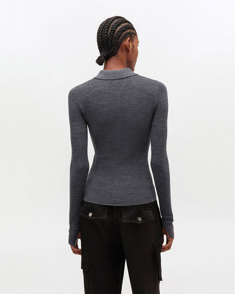 Cienki sweter polo 2601 GANNI z kołnierzykiem. Ma wzór w romby. Zapinany przy dekolcie za pomocą srebrnych, ozdobnych guzików w kształcie logo marki. Sweter ma prosty krój i przylegający do ciała fason oraz długie, wąskie rękawy. Wykonany z miękkiej, ekskluzywnej dzianiny z wełny merynosa.&nbsp;