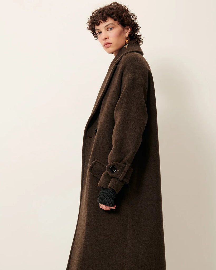 Długi, dwurzędowy płaszcz Mia Lichen francuskiej marki Sessun z aksamitnej tkaniny o podwójnym splocie, tkanej we Włoszech. Ma opadające ramiona, kołnierzyk i szerokie mankiety zapinane na guziki. Posiada kieszenie wpuszczane z patkami. Wykonany z dzianiny z wełną.&nbsp;