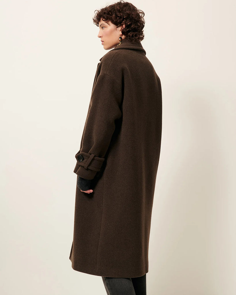 Długi, dwurzędowy płaszcz Mia Lichen francuskiej marki Sessun z aksamitnej tkaniny o podwójnym splocie, tkanej we Włoszech. Ma opadające ramiona, kołnierzyk i szerokie mankiety zapinane na guziki. Posiada kieszenie wpuszczane z patkami. Wykonany z dzianiny z wełną.&nbsp;