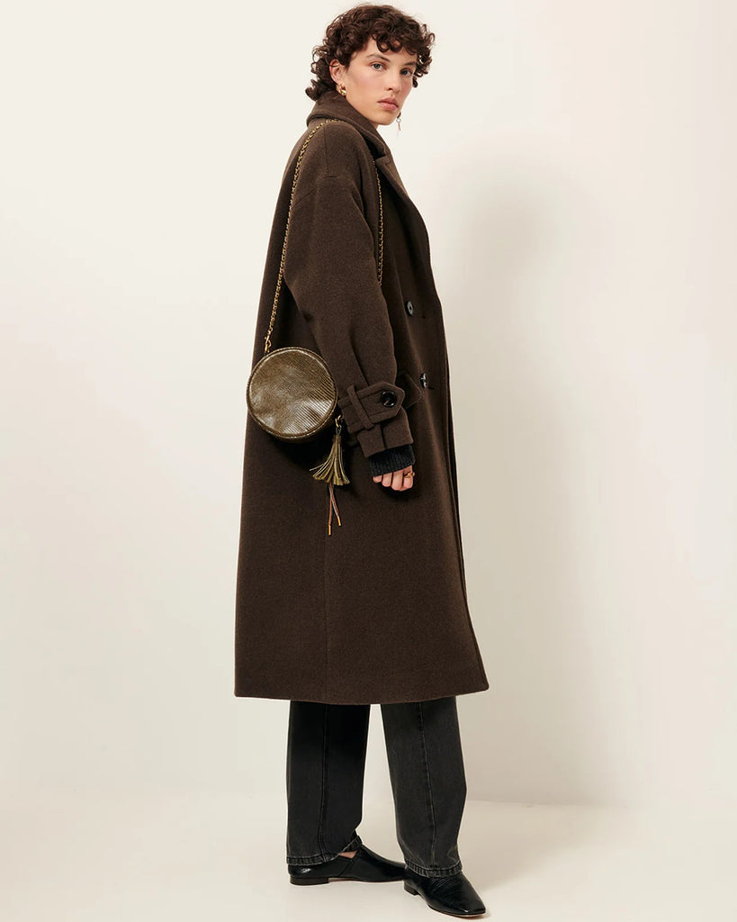 Długi, dwurzędowy płaszcz Mia Lichen francuskiej marki Sessun z aksamitnej tkaniny o podwójnym splocie, tkanej we Włoszech. Ma opadające ramiona, kołnierzyk i szerokie mankiety zapinane na guziki. Posiada kieszenie wpuszczane z patkami. Wykonany z dzianiny z wełną.&nbsp;