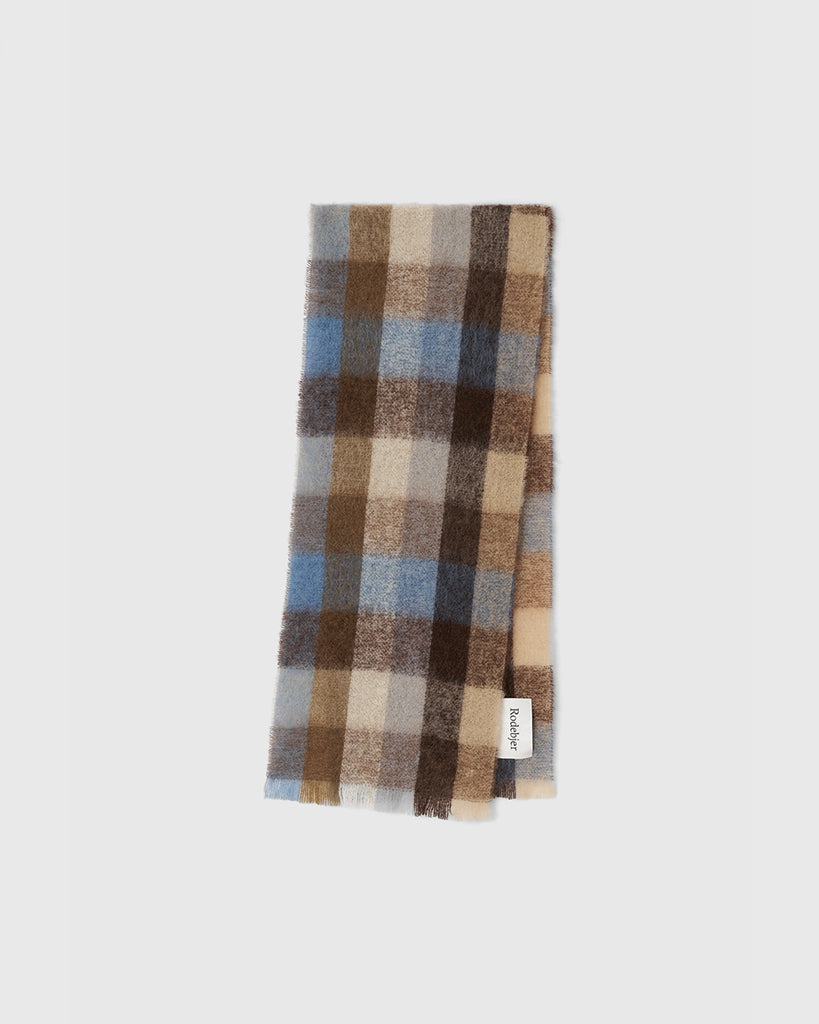 Ciepły, gruby szal Misty Chicory Coffee w kratę z frędzlami i logo marki. Wykonany z miękkiej mieszanki wełny, moheru i alpaki. Idealnie sprawdzi się do jesienno-zimowych stylizacji.&nbsp;