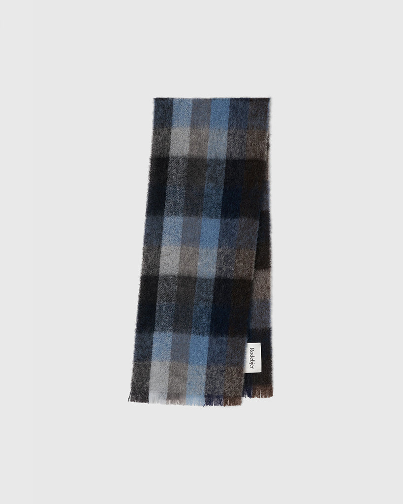 Ciepły, gruby szal Misty Navy w kratę z frędzlami i logo marki. Wykonany z miękkiej mieszanki wełny, moheru i alpaki. Idealnie sprawdzi się do jesienno-zimowych stylizacji.&nbsp;