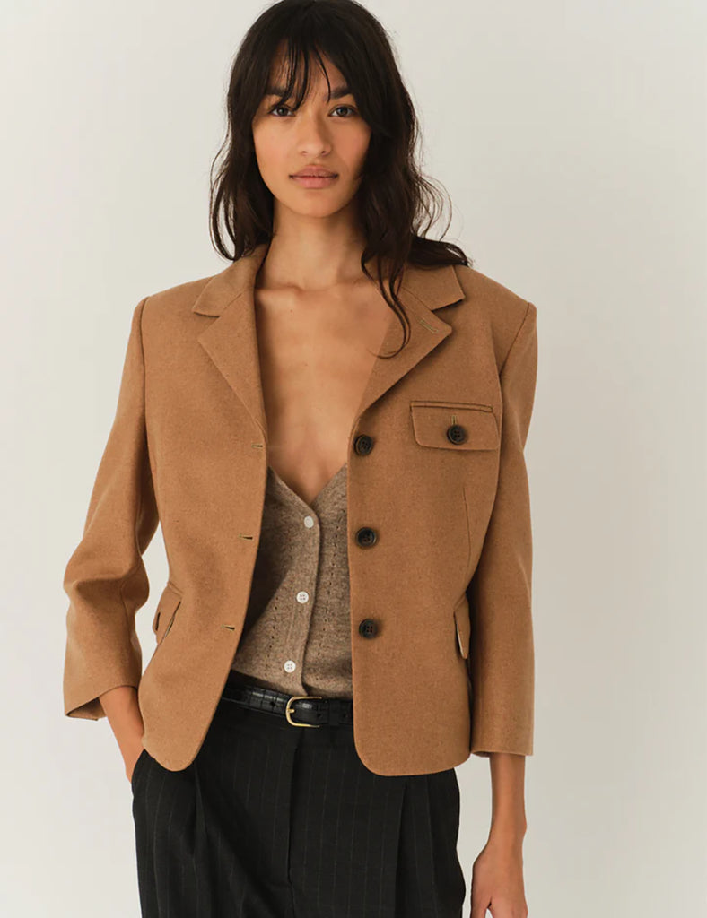 Krótka, dopasowana kurtka Mitch Fitted Camel z kołnierzykiem, rękawami z ozdobnymi guzikami przy mankietach, dwoma przednimi kieszeniami i kieszonką na piersi. Zapinana guziki. Wykonana z dzianiny z wełny z recyklingu. Dopasowany fason nadaje kurtce kobiecy charakter z eleganckim akcentem.&nbsp;