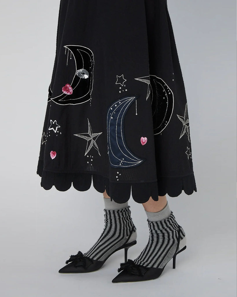 Bawełniana, midi sukienka Embroidered Moon&amp;Star marki STELLA NOVA z okrągłym dekoltem pod szyję i rękawami o długości 3/4. Sukienka ma wyraźnie zaznaczoną talię oraz falbaniaste zakończenie u dołu i przy rękawach. Tył sukienki zdobi subtelne wycięcie w kształcie litery V. Posiada ręcznie haftowane motywy MIDNIGHT. Zapinana na suwak z boku i guzik z tyłu przy szyi.&nbsp;