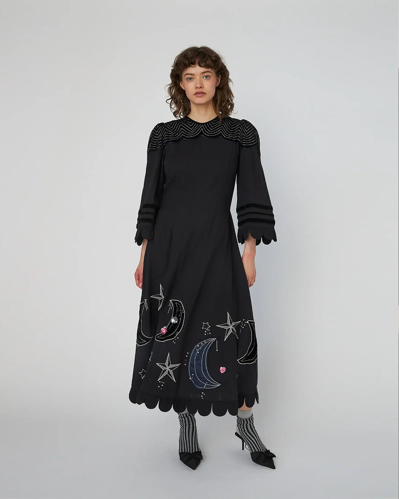 Bawełniana, midi sukienka Embroidered Moon&amp;Star marki STELLA NOVA z okrągłym dekoltem pod szyję i rękawami o długości 3/4. Sukienka ma wyraźnie zaznaczoną talię oraz falbaniaste zakończenie u dołu i przy rękawach. Tył sukienki zdobi subtelne wycięcie w kształcie litery V. Posiada ręcznie haftowane motywy MIDNIGHT. Zapinana na suwak z boku i guzik z tyłu przy szyi.&nbsp;