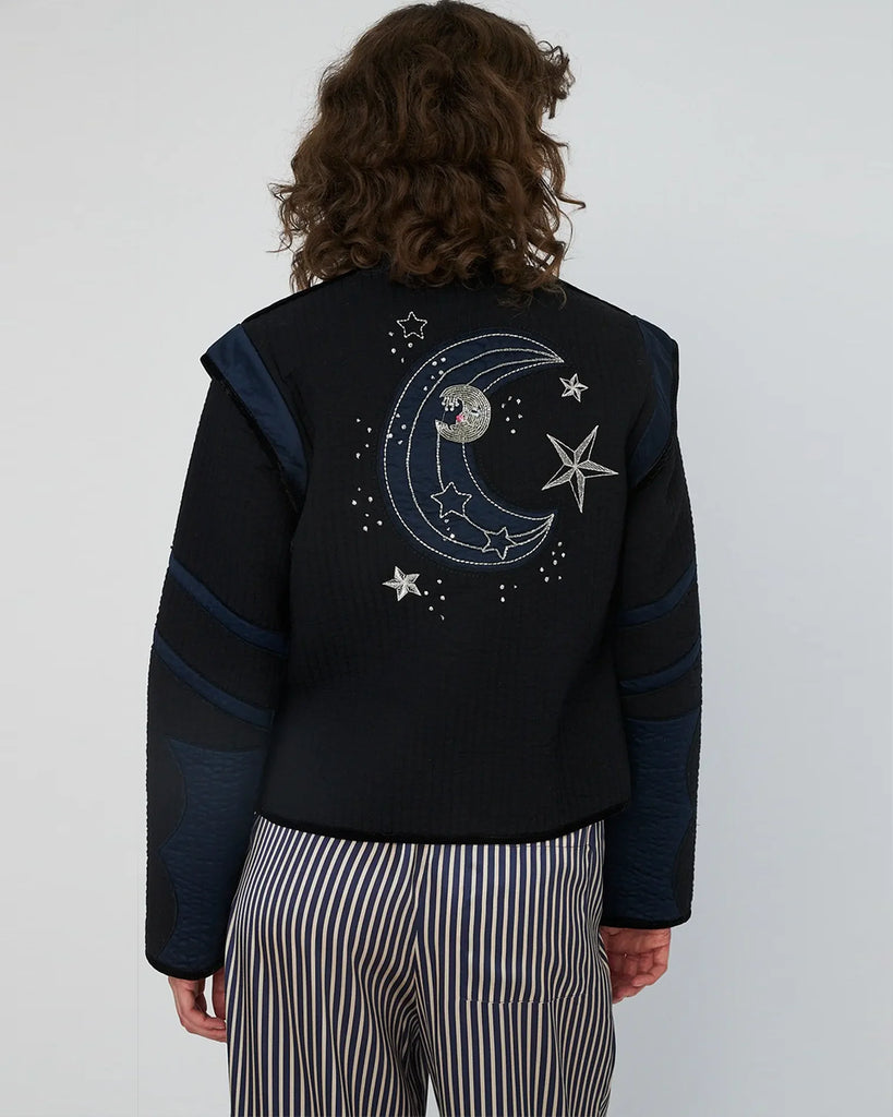 Krótka, czarno-granatowa kurtka Moon&amp;Star Embroidered marki STELLA NOVA o geometrycznym kroju, z wysokim kołnierzem typu stójka i zapięciem na guziki z przodu. Wyróżnia się kontrastowymi wstawkami na klatce piersiowej, ramionach i przy dużych, półokrągłych kieszeniach. Z tyłu posiada haft z motywem gwiazd i księżyca. Sylwetka jest prosta, ale dzięki strukturze i detalom wygląda bardzo architektonicznie i modnie. Wykonana z bawełny organicznej.