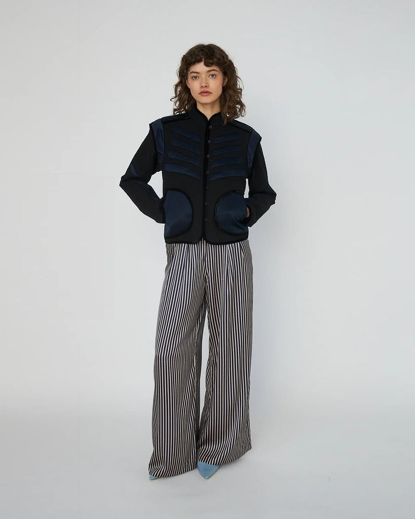 Krótka, czarno-granatowa kurtka Moon&amp;Star Embroidered marki STELLA NOVA o geometrycznym kroju, z wysokim kołnierzem typu stójka i zapięciem na guziki z przodu. Wyróżnia się kontrastowymi wstawkami na klatce piersiowej, ramionach i przy dużych, półokrągłych kieszeniach. Z tyłu posiada haft z motywem gwiazd i księżyca. Sylwetka jest prosta, ale dzięki strukturze i detalom wygląda bardzo architektonicznie i modnie. Wykonana z bawełny organicznej.