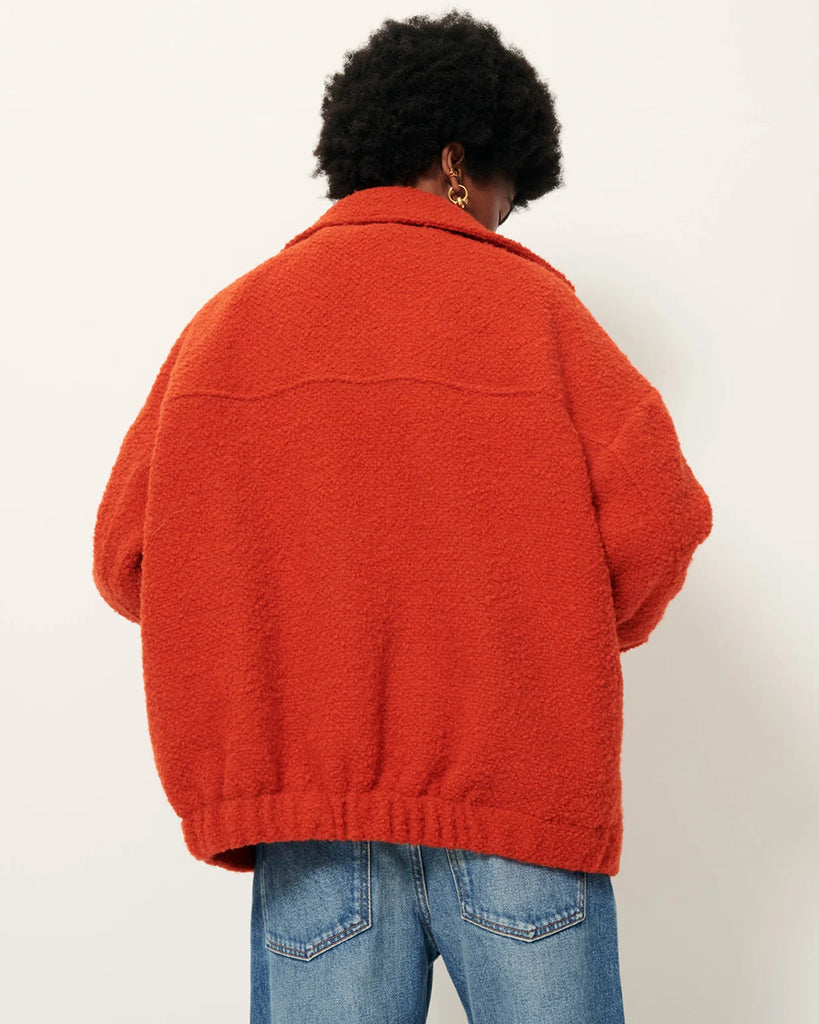 Krótki, wełniany płaszcz Morrison Witamin marki Sessun z opadającymi ramionami i kołnierzykiem. Z przodu posiada naszyte kieszenie zapinane na zatrzaski oraz elastyczną talią i gumkę z tyłu. Zapinany na guziki. Wykonany we Włoszech z grubej, barwionej tkaniny o splocie koszykowym.