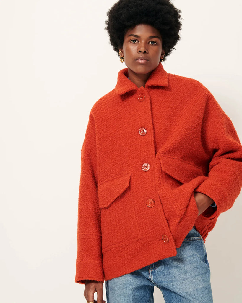 Krótki, wełniany płaszcz Morrison Witamin marki Sessun z opadającymi ramionami i kołnierzykiem. Z przodu posiada naszyte kieszenie zapinane na zatrzaski oraz elastyczną talią i gumkę z tyłu. Zapinany na guziki. Wykonany we Włoszech z grubej, barwionej tkaniny o splocie koszykowym.