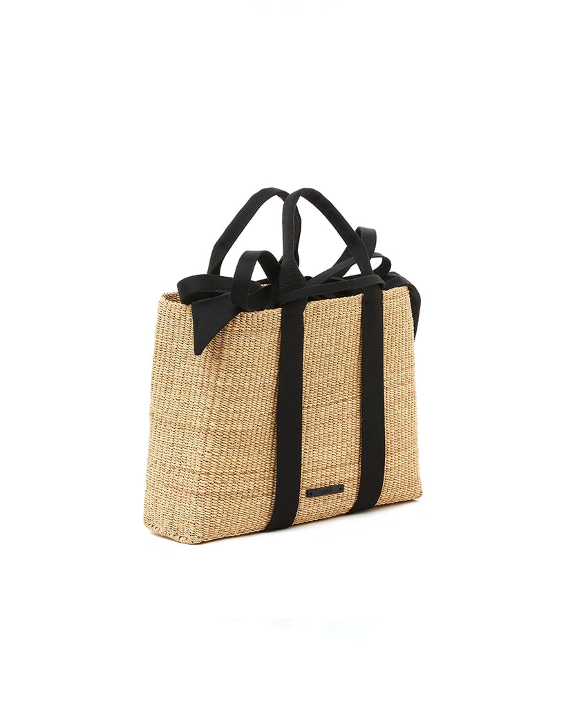 Średniej wielkości, ręcznie pleciony kosz JEROME - NATURAL x BLACK HDL x BLACK COTTON francuskiej marki Muun. Posiada prostokątny kształt, dwie mocne, plecione materiałowe rączki w kolorze ciemnozielonym do wygodnego trzymania w dłoni i zawieszenia na ramieniu. Wewnątrz koszyka znajduje się wiązana, wyciągana bawełniana, czarna torebka