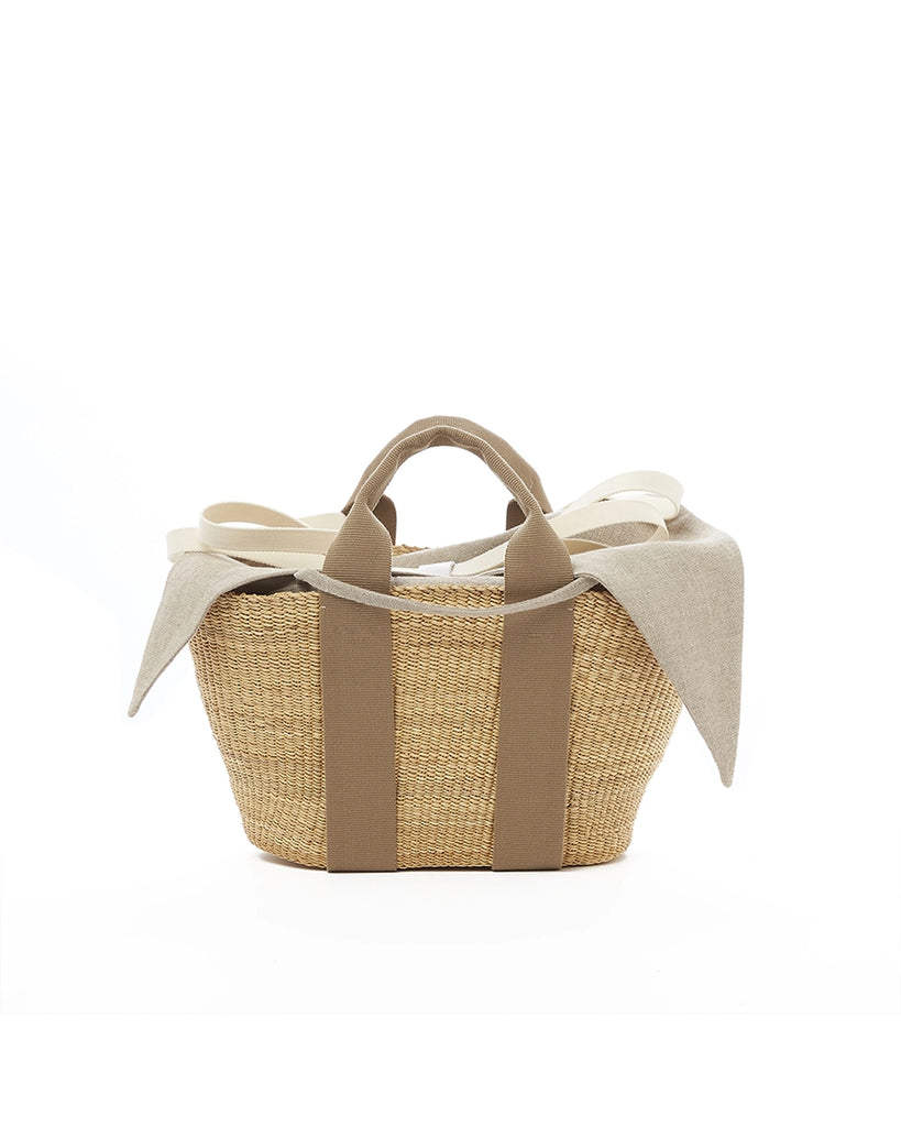 Średniej wielkości, ręcznie pleciony kosz GEORGE - NATURAL x BEIGE HDL x NATURAL LINEN francuskiej marki Muun. Posiada trapezowy kształt, dwie mocne, materiałowe rączki do wygodnego trzymania w dłoni oraz długi, cienki pasek do zawieszenia na ramieniu. 