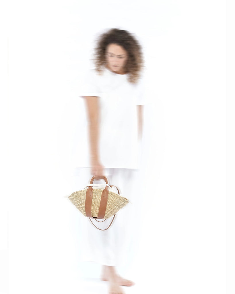 Mała, ręcznie pleciona torebka koszyk MINI SOPHIE - NATURAL x Tan HDL x Ecru COTTON francuskiej marki Muun. Posiada wachlarzowy kształt, dwie mocne, skórzane, brązowe rączki do wygodnego trzymania w dłoni oraz długi, cienki pasek do zawieszenia na ramieniu. 