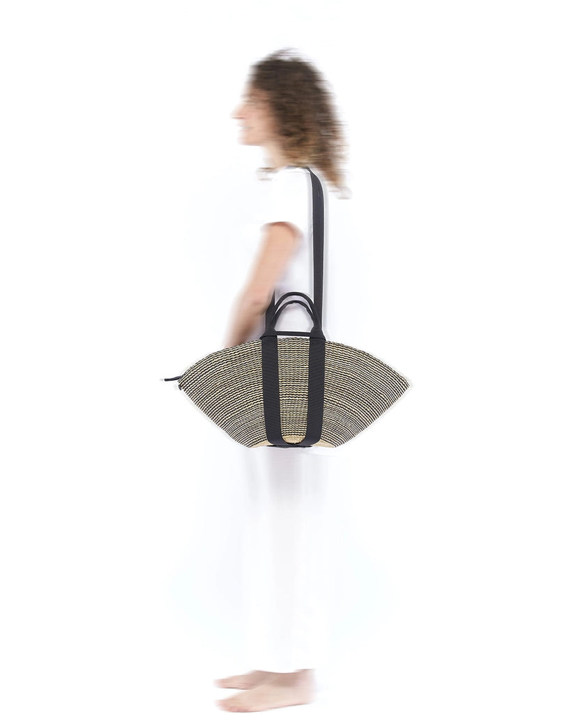 Średniej wielkości, ręcznie pleciony kosz SOPHIE - NATURALxBLACK x BLACK HDL x BLACK COTTON francuskiej marki Muun. Posiada wachlarzowy kształt, dwie mocne, materiałowe rączki do wygodnego trzymania w dłoni oraz długi, cienki pasek do zawieszenia na ramieniu. 