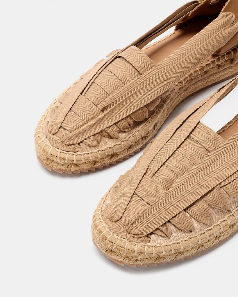 Ręcznie wykonane, hiszpańskie, wkładane espadryle SOC Trail Naguisa. Z przodu wykonane z płótna i plecione za pomocą bawełnianej, szerokiej wstążki wiązanej na kokardę na pięcie. Zapiętek butów wykonany jest z miękkiej, krowiej skóry