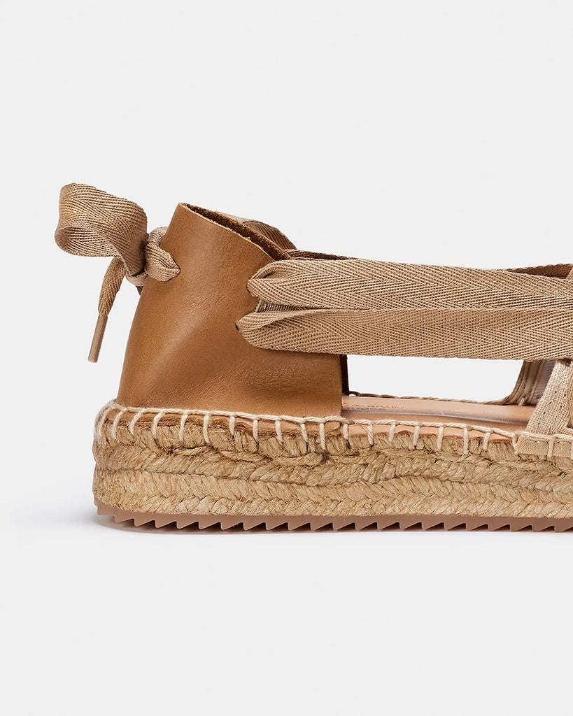 Ręcznie wykonane, hiszpańskie, wkładane espadryle SOC Trail Naguisa. Z przodu wykonane z płótna i plecione za pomocą bawełnianej, szerokiej wstążki wiązanej na kokardę na pięcie. Zapiętek butów wykonany jest z miękkiej, krowiej skóry