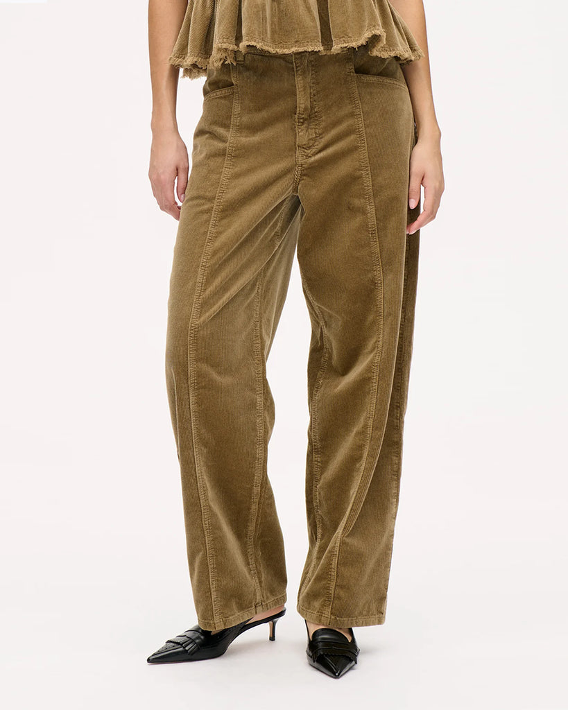 Luźne spodnie Nara Savannah Tan z wysokim stanem, szerokimi nogawkami oraz widocznymi z przodu, i z tyłu szwami. Zapinane na zamek błyskawiczny i guzik. Posiadają kieszenie. Wykonane z miękkiego, elastycznego sztruksu.&nbsp;