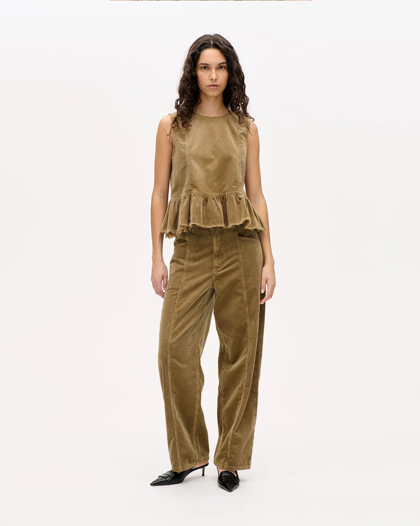 Luźne spodnie Nara Savannah Tan z wysokim stanem, szerokimi nogawkami oraz widocznymi z przodu, i z tyłu szwami. Zapinane na zamek błyskawiczny i guzik. Posiadają kieszenie. Wykonane z miękkiego, elastycznego sztruksu.&nbsp;