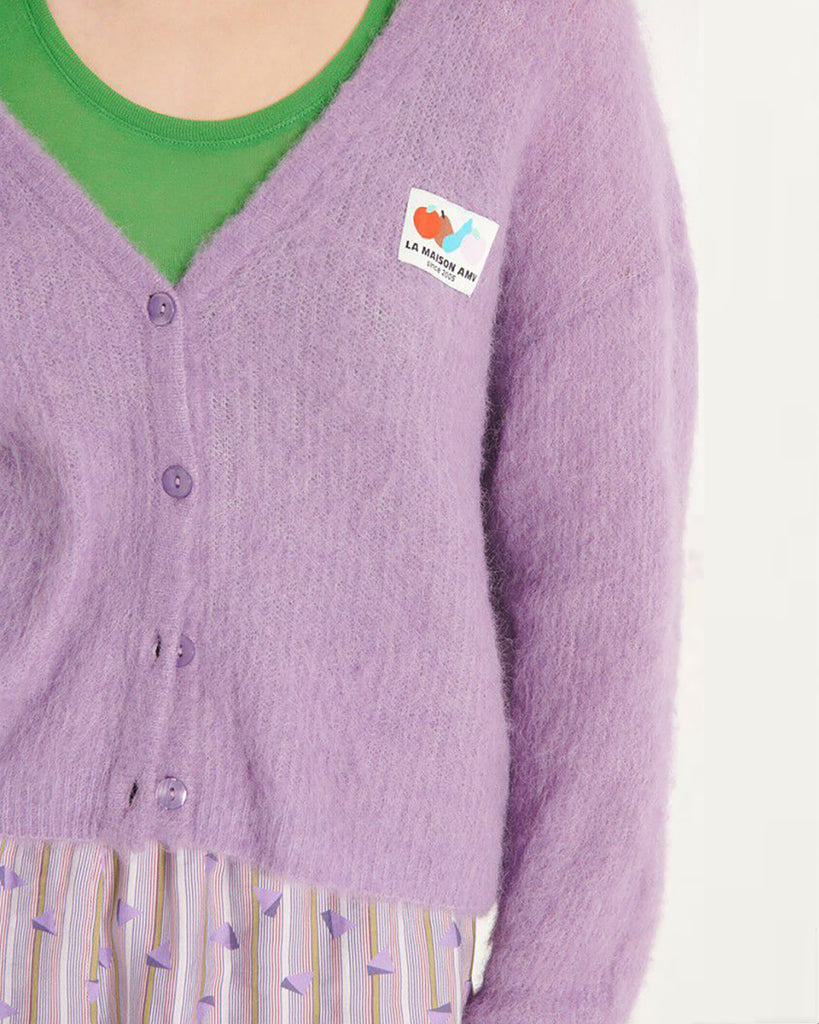 Oversizowy, miękki kardigan Nenybay Violet marki American Vintage z długim rękawem i dekoltem w serek. Zapinany na guziki. Posiada naszywkę z logo na piersi. Zakończony ściągaczami. Wykonany z lekkiej dzianiny z alpaką. Noś go samodzielnie lub połącz z innymi elementami garderoby, aby stworzyć warstwowy, codzienny look.&nbsp;