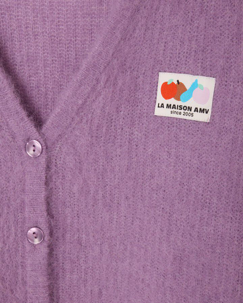 Oversizowy, miękki kardigan Nenybay Violet marki American Vintage z długim rękawem i dekoltem w serek. Zapinany na guziki. Posiada naszywkę z logo na piersi. Zakończony ściągaczami. Wykonany z lekkiej dzianiny z alpaką. Noś go samodzielnie lub połącz z innymi elementami garderoby, aby stworzyć warstwowy, codzienny look.&nbsp;